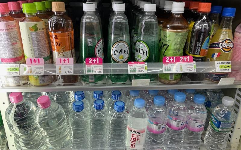 Manufacturers of bottled water and beverages must use a certain percentage of recycled materials in bottle production. Shown are drinks on Feb. 26 displayed in the cooler section of a convenience store in Seoul. (Kim Seon Ah)