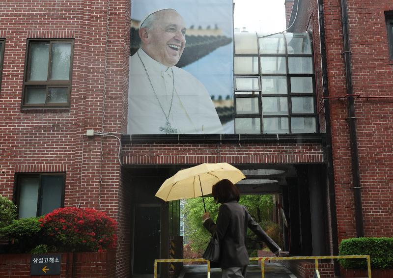 The Vatican on the morning of April 21 announced the death of Pope Francis at age 88. Shown is a picture of the late pope on the exterior wall of the spiritual center building within Myeongdong Cathedral in Seoul's Jung-gu District. (Yonhap News)