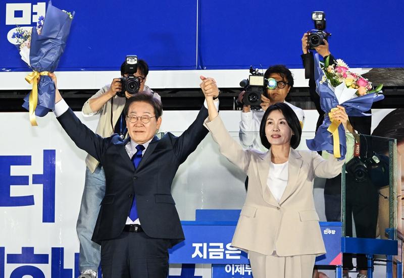 Presidential candidate Lee Jaemyung and his wife Kim Hyekyung in the wee hours of June 4 raise their arms in victory with a bouquet of flowers after hearing of his victory in the presidential election held the day before at a broadcast event for vote counting hosted by the Democratic Party of Korea near the National Assembly in Seoul's Yeongdeungpo-gu District. 