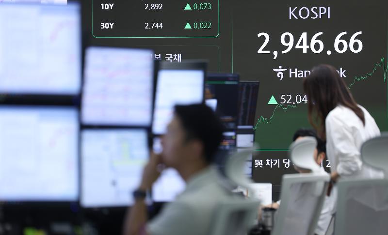 The dealers' room at the main branch of Hana Bank on June 16 in Seoul's Jung-gu District shows the benchmark Korea Composite Stock Price Index recovering to the 2,940 level for the first time in three years and five months. (Yonhap News)    