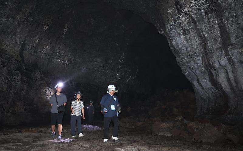 Members of the second expedition on July 9 walk inside Gimnyeonggul Cave on a guided tour. 