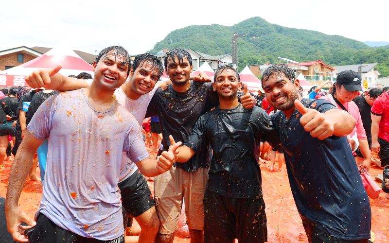 Foreign tourists on Aug. 2 give a thumbs up at the annual Hwacheon Tomato Festival in Sachangri, a village in Sanae-myeon Township of Hwacheon-gun County, Gangwon-do Province.  