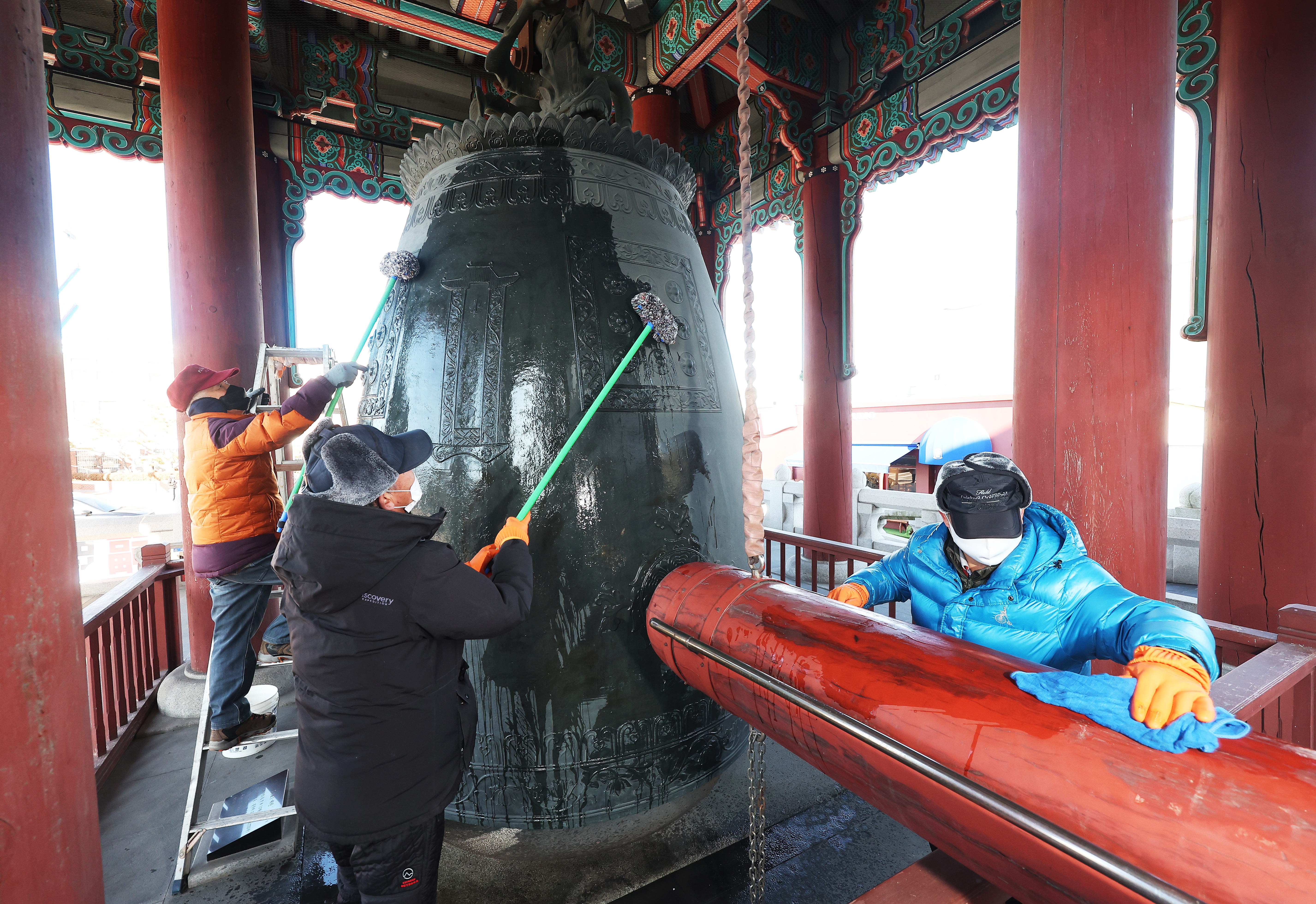 Staff on Dec. 30 polish the large bell at Yeomingak Bell Pavilion in front of Suwon Hwaseong Fortress in Suwon