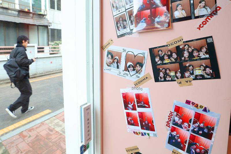Photos of tourists are plastered on the walls of an instant photo studio in Seongsu-dong. 