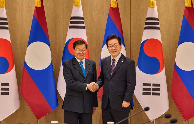 President Lee Jae Myung (right) and visiting Laotian President Thongloun Sisoulith on Dec. 15 shake hands at the presidential office in Seoul. 