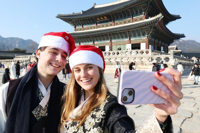 A couple on Dec. 23, 2025, poses for a selfie at Gyeongbokgung Palace in Seoul's Jongno-gu District. (Lee Jeongwoo)  