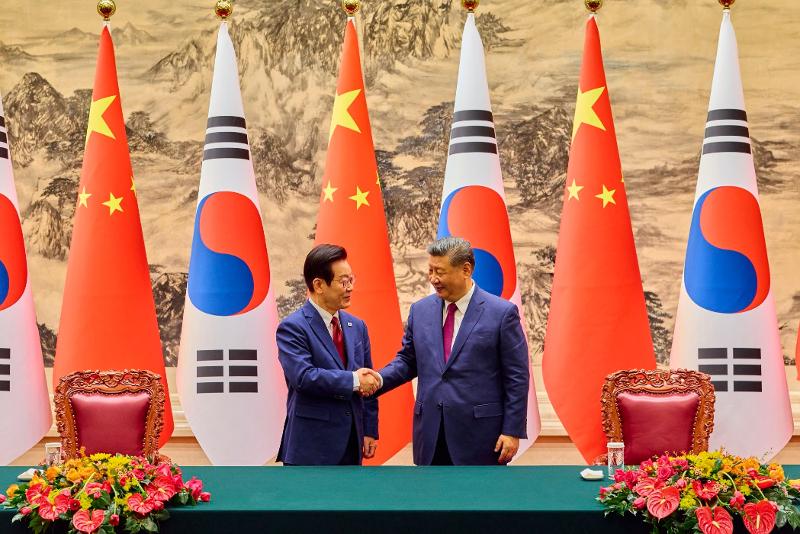President Lee Jae Myung (left) and Chinese President Xi Jinping on Jan. 5 shake hands at the Great Hall of the People in Beijing. (President Lee's Facebook account)  