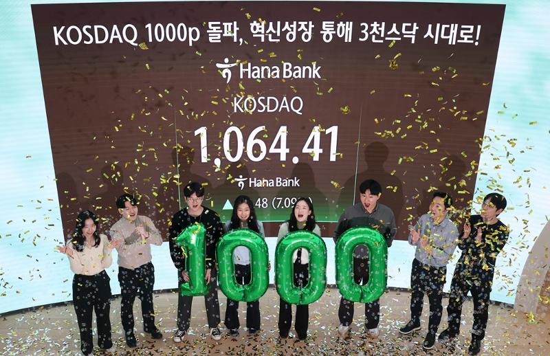 Dealers on Jan. 26 celebrate the secondary stock market KOSDAQ breaking 1,000 for the first time in four years at the dealing room of Hana Bank's headquarters in Seoul's Jung-gu District. (Yonhap News)