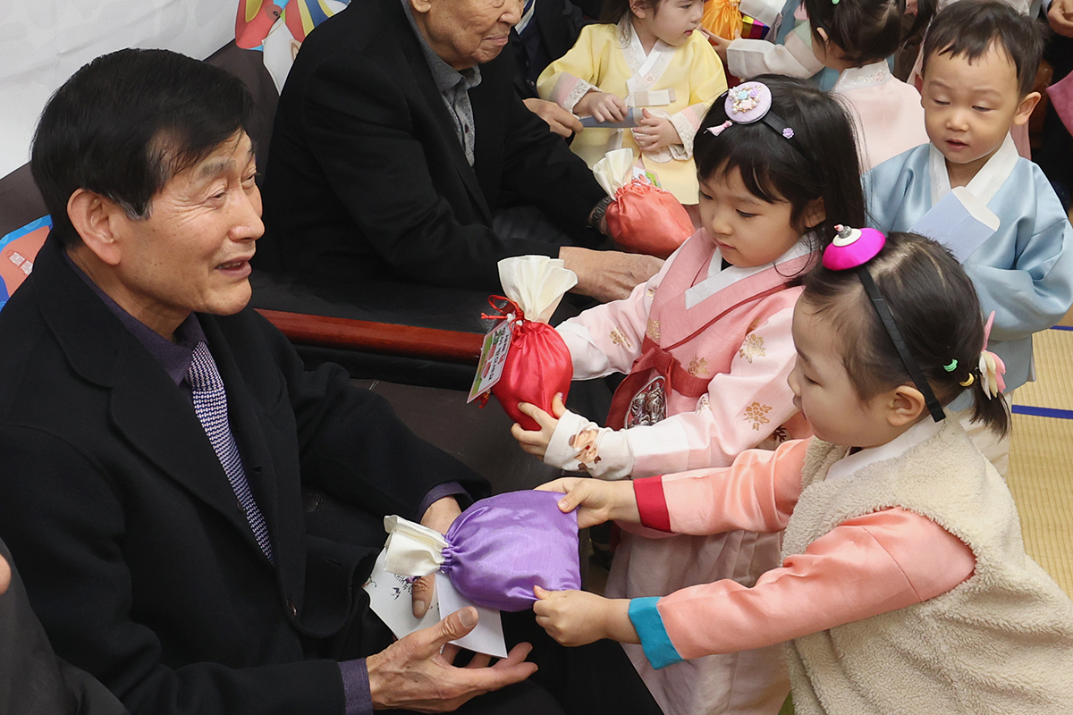 Children dressed in Hanbok (traditional clothing) from a daycare center in Seoul's Songpa-gu District on Feb. 11 give tteok (rice cakes) at a facility for senior citizens after performing sebae (traditional prostration), a custom on Seollal (Lunar New Year).