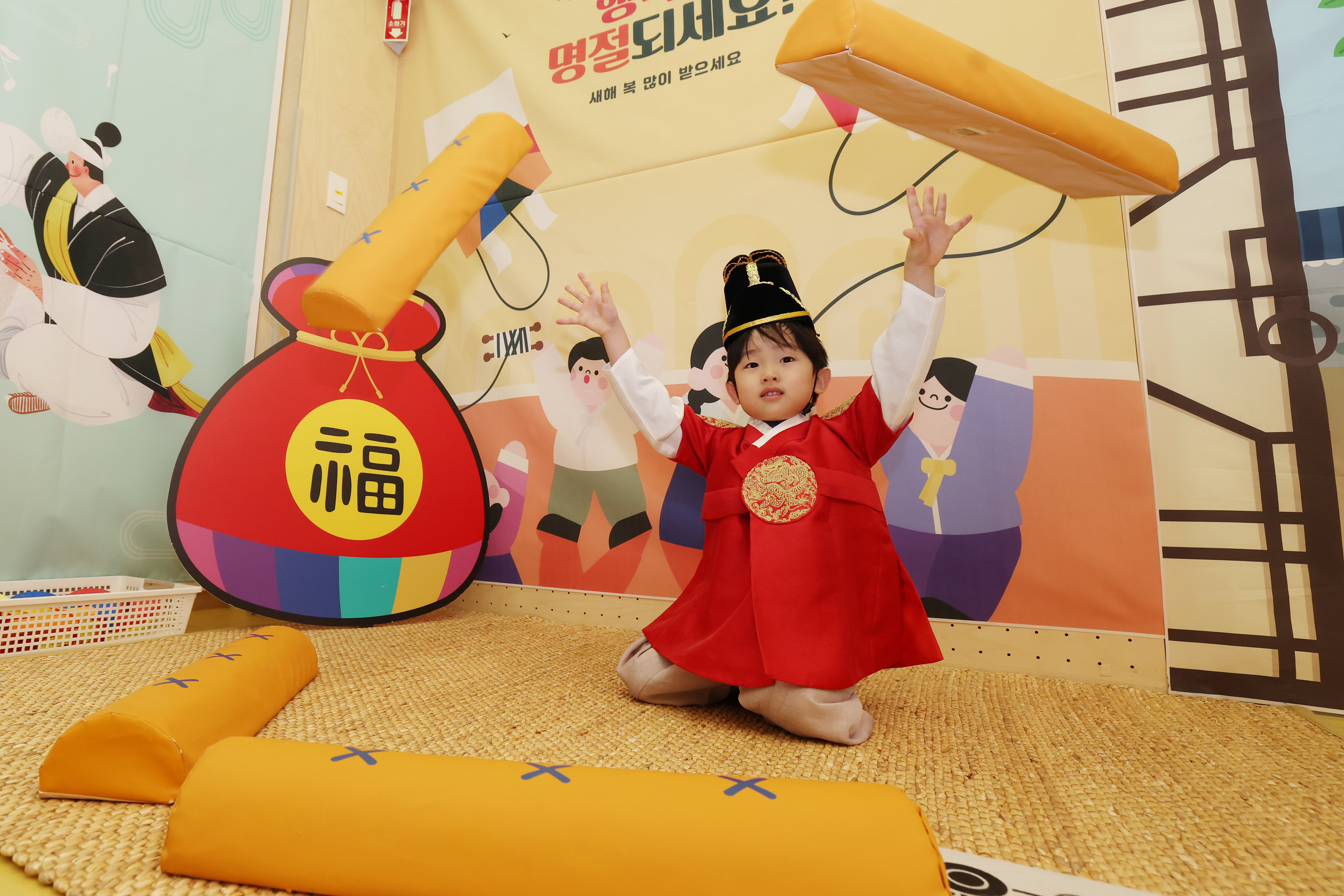 A child on Feb. 12 throws a large stick of the traditional board game yunnori at an interactive center for traditional games within a kids cafe in Seoul's Gangdong-gu District.