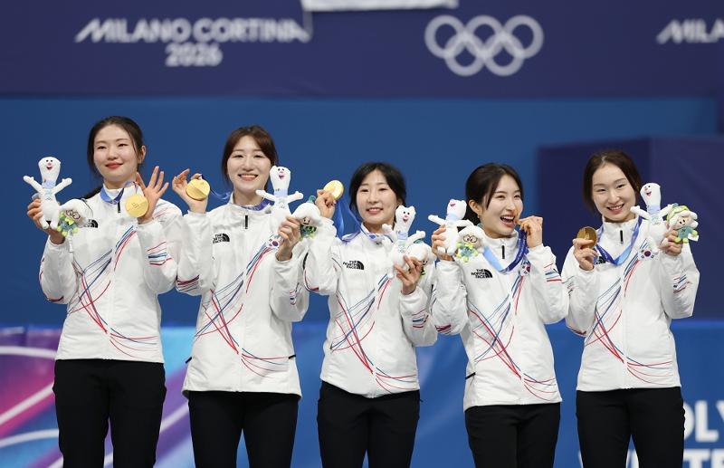 The national women's team on Feb. 18 pose with their gold medals at the medal ceremony held at the Milano Ice Skating Arena in Milan after winning the 3,000-m short track relay at the Milan Cortina Winter Olympics in Italy. From left are Shim Sukhee, Noh Dohee, Lee Soyeon, Kim Gilli and Choi Minjeong.  