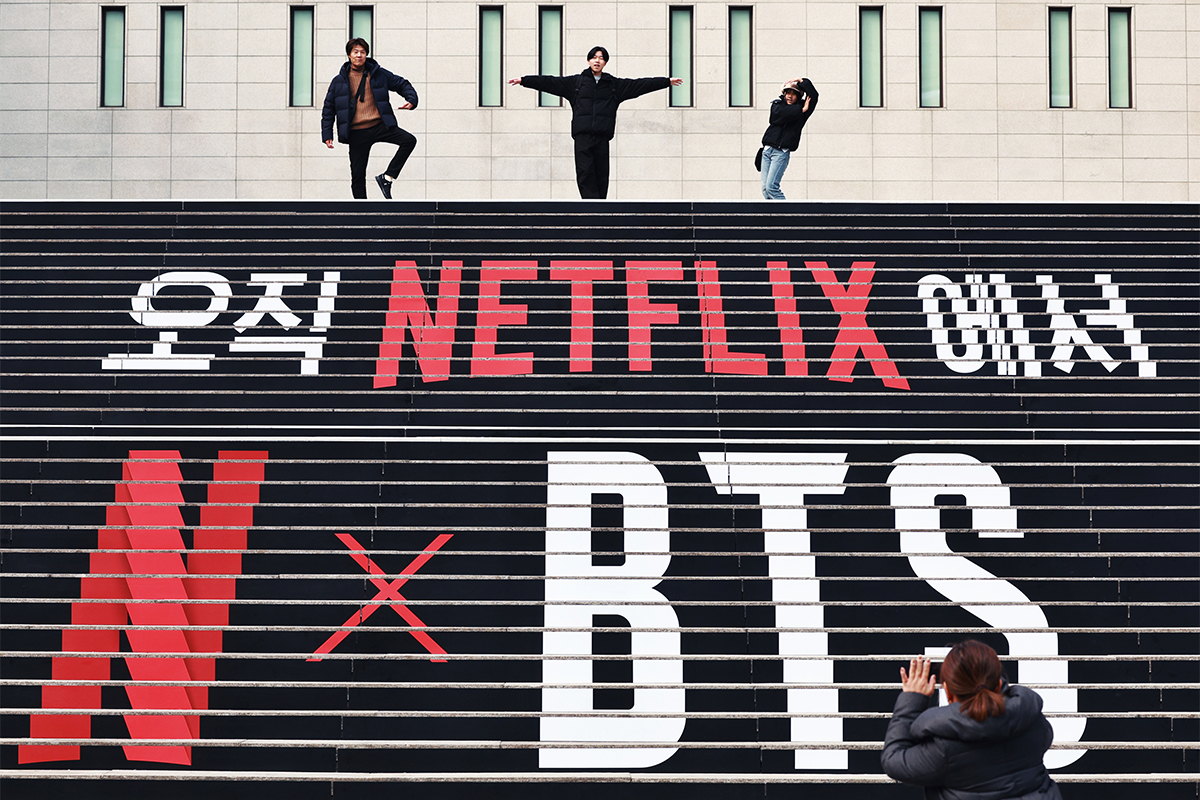 Tourists on March 11 pose on the steps of Sejong Center for the Performing Arts in Seou