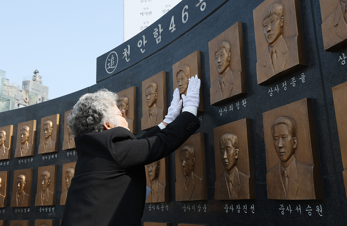 A relative of a crew member on the naval corvette Cheonan on March 26 touches an engraving of his face on a memorial monument in Pyeongtaek,_