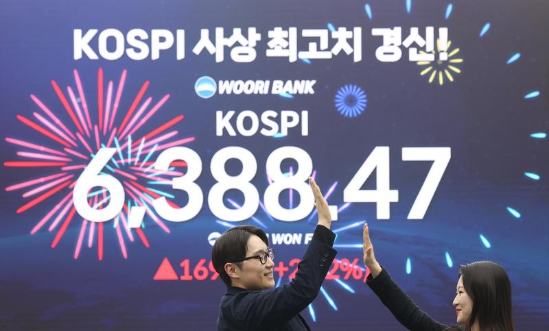 A massive screen on April 21 shows the main stock price index KOSPI breaking its record high with 6,388.47 at the trading room of Woori Bank headquarters in Seoul's Jung-gu District. (Yonhap News)