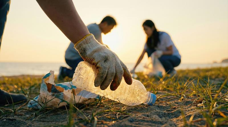 People help clean up a beach by collecting plastic waste. (iClickArt) Unauthorized reproduction and redistribution of this image is prohibited under copyright law.  