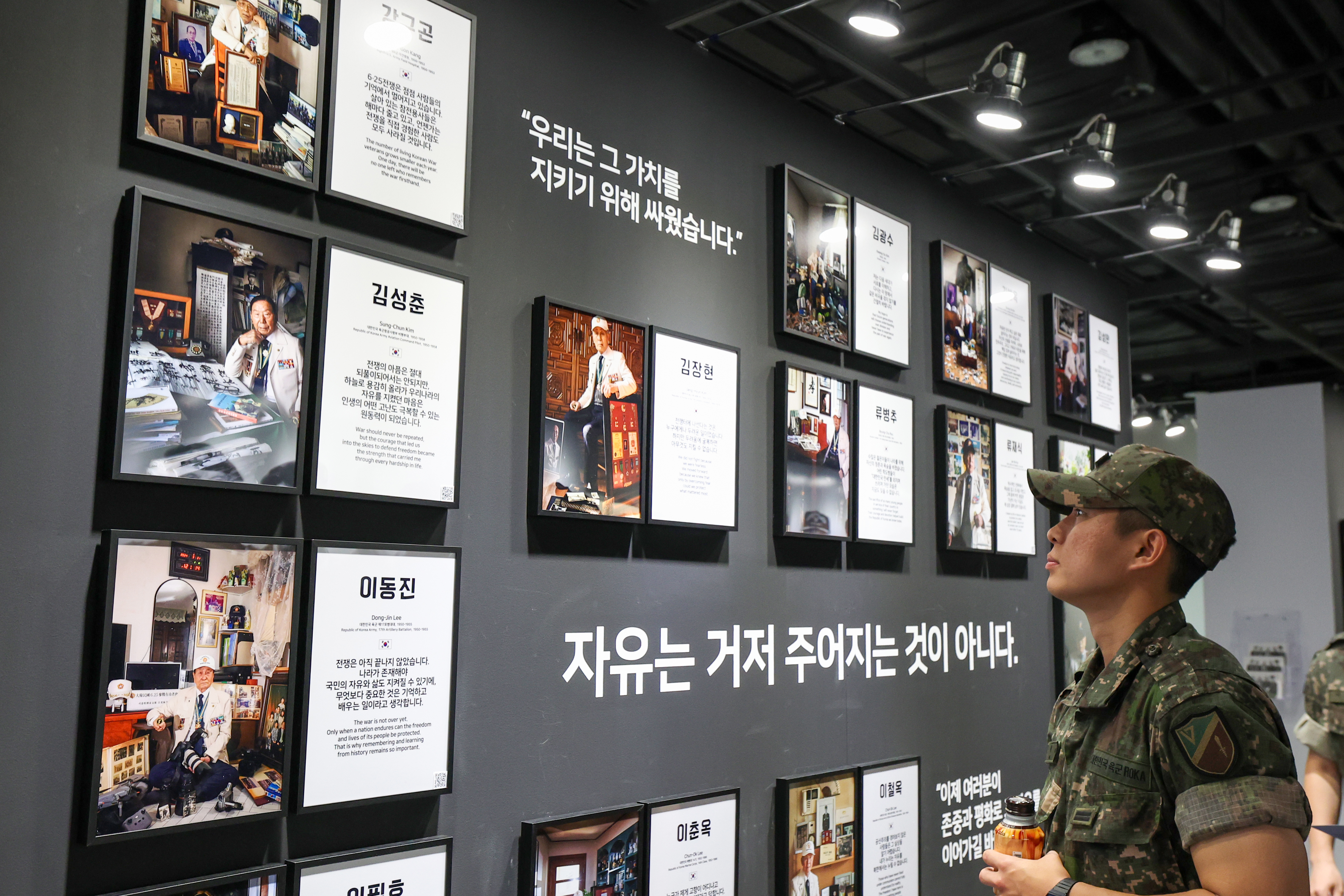 A soldier on June 19 look at photos of war veterans at the exhibition 