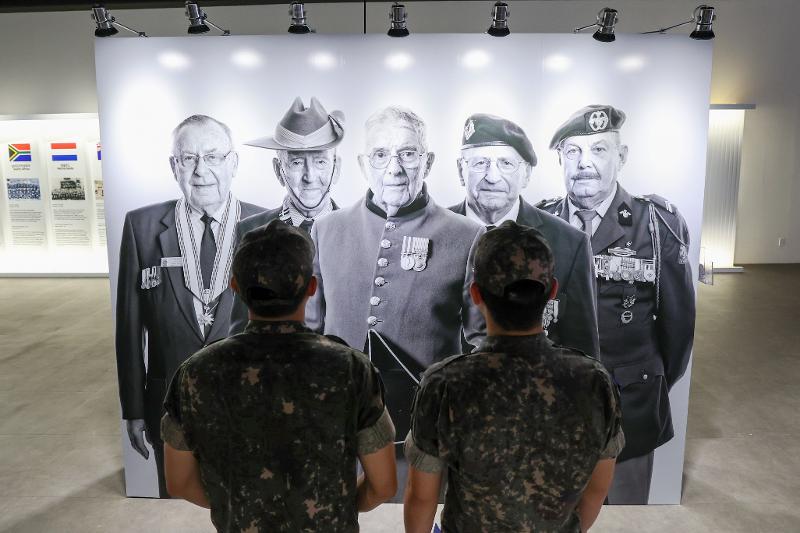 Soldiers on June 19 look at photos of war veterans at the exhibition 