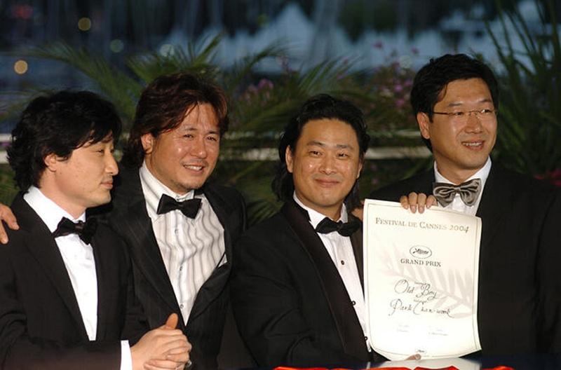 From left are producer Syd Lim (Lim Seung-yong), CEO of Yong Film, actor Choi Min-sik, and directors Park Chan-wook and Chung Chung-hoon on May 22, 2004, taking a group photo after 