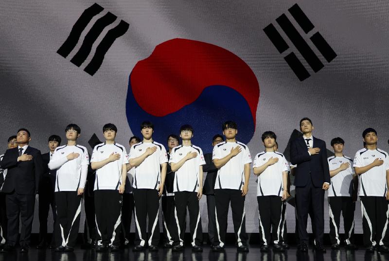 The national esports team including superstar Lee Sang-hyeok (fifth from left in front row), aka Faker, on Aug. 25 salutes the national flag at the squad's launching ceremony for this year's Aichi-Nagoya Summer Asian Games in Japan at Cube Convention Center in Seoul's Mapo-gu District. (Yonhap News) 