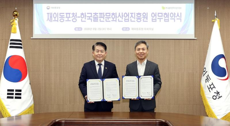 Overseas Koreans Agency (OKA) Commissioner Kim Kyung-hyup (left) and Kim Seung-su, president of the Publication Industry Promotion Agency of Korea, on Sept. 2 hold copies of a memorandum of understanding they signed at the main conference room of OKA headquarters in Songdo International Business District of Incheon's Yeonsu-gu District. (OKA)